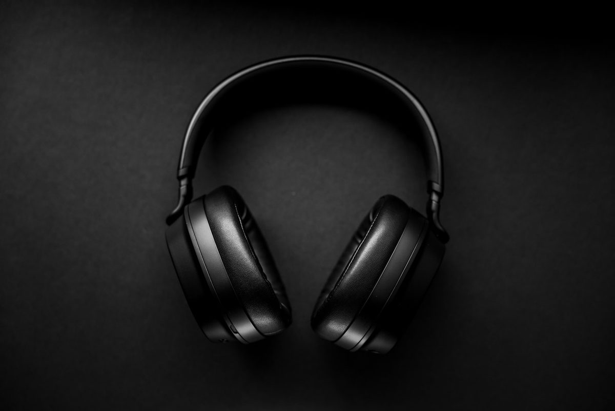 Black over-ear headphones centered on a dark seamless background